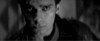 Movie still from “A Girl Walks Home Alone at Night” (2014), directed by Ana Lily Amirpour – A man's face in black and white; Extreme Close Up shot, Low angle