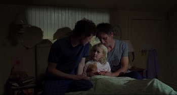 Movie still from “A History of Violence” (2005), directed by David Cronenberg – Two men and a little girl sitting on a bed; Medium shot, Over the shoulder angle