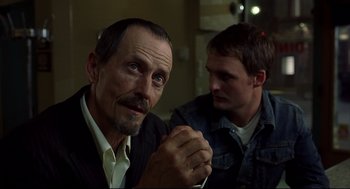 Movie still from “A History of Violence” (2005), directed by David Cronenberg – Two men sitting next to each other in front of a wall; Close Up shot, Low angle