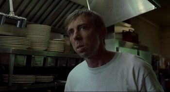 Movie still from “A History of Violence” (2005), directed by David Cronenberg – A man standing in a kitchen with plates on the counter; Close Up shot, Low angle