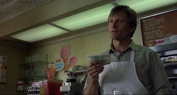 Movie still from “A History of Violence” (2005), directed by David Cronenberg – A man in a white apron holding a dollar bill; Close Up shot, Low angle