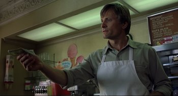Movie still from “A History of Violence” (2005), directed by David Cronenberg – A man wearing an apron is standing in front of a counter; Close Up shot, Low angle