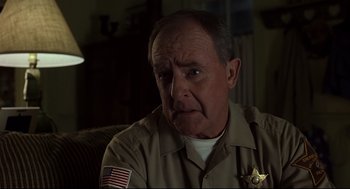 Movie still from “A History of Violence” (2005), directed by David Cronenberg – An older man wearing a sheriff's uniform; Close Up shot, Over the shoulder angle