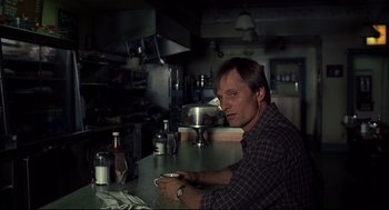 Movie still from “A History of Violence” (2005), directed by David Cronenberg – A man sitting at a counter in a kitchen; Close Up shot, Over the shoulder angle