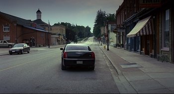 Movie still from “A History of Violence” (2005), directed by David Cronenberg – A car is parked on the side of the street; Extreme Wide shot, High angle