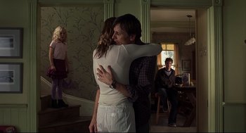 Movie still from “A History of Violence” (2005), directed by David Cronenberg – A man and a woman hugging in a living room; Medium shot, Over the shoulder angle