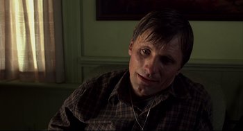 Movie still from “A History of Violence” (2005), directed by David Cronenberg – A person sitting on a couch; Close Up shot, High angle