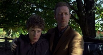 Movie still from “A History of Violence” (2005), directed by David Cronenberg – A man standing next to a young boy in front of a tree; Close Up shot, Low angle