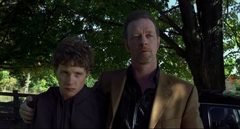 Movie still from “A History of Violence” (2005), directed by David Cronenberg – A man and a boy standing next to each other under a tree; Close Up shot, Low angle