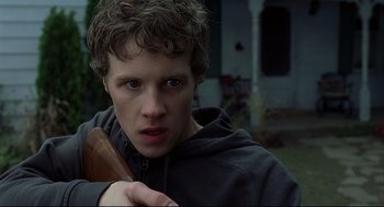 Movie still from “A History of Violence” (2005), directed by David Cronenberg – A young man holding a baseball bat while wearing a hoodie; Close Up shot, Low angle