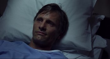 Movie still from “A History of Violence” (2005), directed by David Cronenberg – A person laying in a hospital bed; Close Up shot, Overhead angle