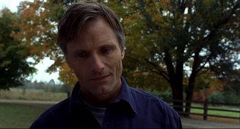Movie still from “A History of Violence” (2005), directed by David Cronenberg – A person wearing a blue shirt near a tree; Close Up shot, Low angle