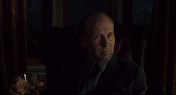 Movie still from “A History of Violence” (2005), directed by David Cronenberg – A man in a suit and tie sitting in a chair; Close Up shot, Low angle