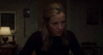 Movie still from “A History of Violence” (2005), directed by David Cronenberg – A woman sitting in a dark room looking at the camera; Close Up shot, Low angle