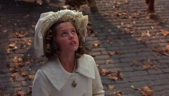 Movie still from “A Little Princess” (1995), directed by Alfonso Cuarón – A young girl wearing a white dress and a white hat; Close Up shot, High angle