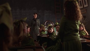 Movie still from “A Little Princess” (1995), directed by Alfonso Cuarón – A group of people in green uniforms sitting in a classroom; Medium shot, Over the shoulder angle