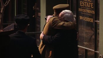 Movie still from “A Little Princess” (1995), directed by Alfonso Cuarón – A man in a uniform hugging an older woman; Medium shot, Over the shoulder angle