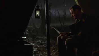 Movie still from “A Little Princess” (1995), directed by Alfonso Cuarón – A man sitting on a chair in the rain; Medium shot, Low angle