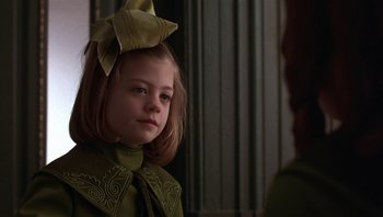 Movie still from “A Little Princess” (1995), directed by Alfonso Cuarón – A little girl with a bow on her head; Close Up shot, Over the shoulder angle