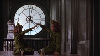 Movie still from “A Little Princess” (1995), directed by Alfonso Cuarón – Two little girls are sitting on the floor and one of them is holding out her hand; Medium shot, Low angle