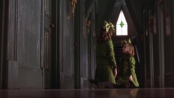 Movie still from “A Little Princess” (1995), directed by Alfonso Cuarón – Two little girls dressed in green are standing in front of a window; Wide shot, High angle