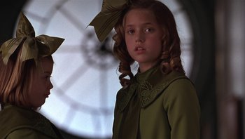 Movie still from “A Little Princess” (1995), directed by Alfonso Cuarón – A young girl in a green dress with a bow in her hair; Close Up shot, Low angle