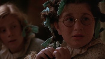 Movie still from “A Little Princess” (1995), directed by Alfonso Cuarón – A young girl wearing a wig and glasses; Close Up shot, High angle
