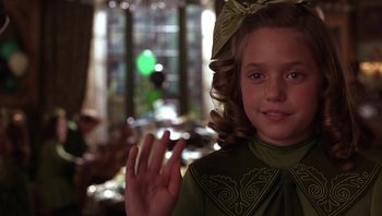 Movie still from “A Little Princess” (1995), directed by Alfonso Cuarón – A young girl in a green dress waving; Close Up shot, Over the shoulder angle