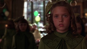 Movie still from “A Little Princess” (1995), directed by Alfonso Cuarón – A young girl wearing a green dress with a bow in her hair; Close Up shot, Over the shoulder angle