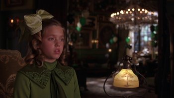 Movie still from “A Little Princess” (1995), directed by Alfonso Cuarón – A young girl in a green shirt and a bow in her hair; Close Up shot, Over the shoulder angle