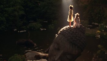 Movie still from “A Little Princess” (1995), directed by Alfonso Cuarón – Two children are standing on top of an elephant statue; Extreme Wide shot, High angle