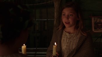 Movie still from “A Little Princess” (1995), directed by Alfonso Cuarón – A young girl holding a lit candle in the dark; Close Up shot, Over the shoulder angle
