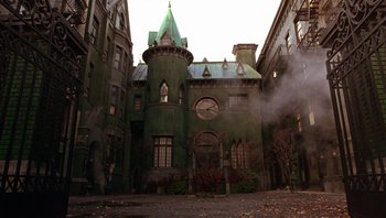 Movie still from “A Little Princess” (1995), directed by Alfonso Cuarón – An old green building with a clock on the front of it; Extreme Wide shot, Low angle