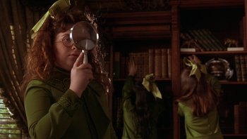 Movie still from “A Little Princess” (1995), directed by Alfonso Cuarón – A woman with a magnifying glass in a library; Medium shot, Over the shoulder angle