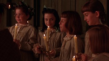Movie still from “A Little Princess” (1995), directed by Alfonso Cuarón – A group of young girls standing next to each other holding lit candles; Close Up shot, Over the shoulder angle