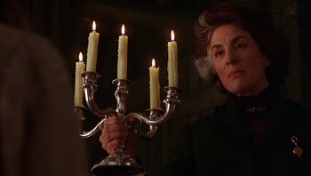 Movie still from “A Little Princess” (1995), directed by Alfonso Cuarón – An older woman holding a candelabrum with lit candles; Close Up shot, Low angle