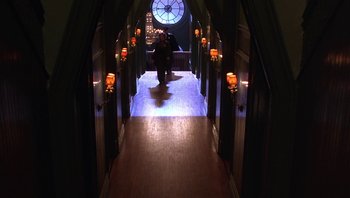 Movie still from “A Little Princess” (1995), directed by Alfonso Cuarón – A person walking down a long hallway in a building; Wide shot, High angle