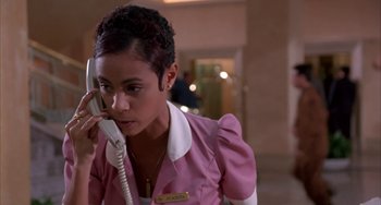 Movie still from “A Low Down Dirty Shame” (1994), directed by Keenen Ivory Wayans – A woman talking on a phone while wearing a pink jacket; Close Up shot, High angle