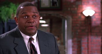 Movie still from “A Low Down Dirty Shame” (1994), directed by Keenen Ivory Wayans – A person wearing a suit and tie; Close Up shot, Low angle