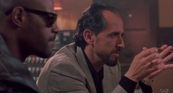 Movie still from “A Low Down Dirty Shame” (1994), directed by Keenen Ivory Wayans – A man in a suit sitting next to another man in a suit; Close Up shot, Over the shoulder angle