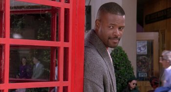 Movie still from “A Low Down Dirty Shame” (1994), directed by Keenen Ivory Wayans – A man standing in front of a red phone booth; Close Up shot, Low angle