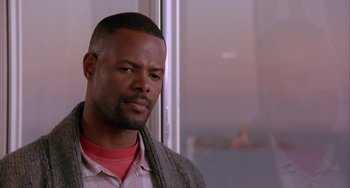 Movie still from “A Low Down Dirty Shame” (1994), directed by Keenen Ivory Wayans – A man with a beard and a sweater on looking out of a window; Close Up shot, Low angle