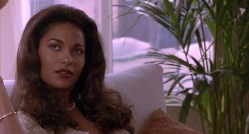 Movie still from “A Low Down Dirty Shame” (1994), directed by Keenen Ivory Wayans – A woman sitting on top of a couch in a living room; Close Up shot, High angle