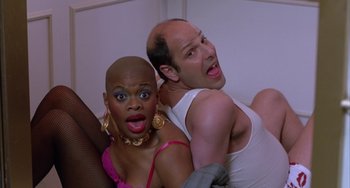 Movie still from “A Low Down Dirty Shame” (1994), directed by Keenen Ivory Wayans – A man and a woman are posing for a picture; Medium shot, Low angle