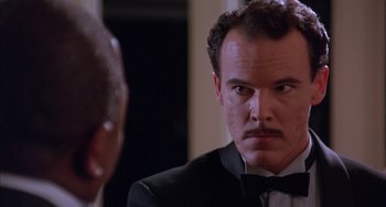 Movie still from “A Low Down Dirty Shame” (1994), directed by Keenen Ivory Wayans – A man in a tuxedo looking into a mirror; Close Up shot, Low angle