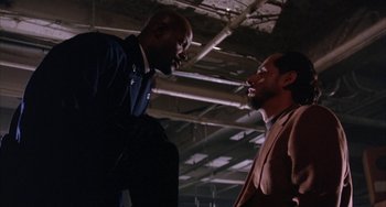 Movie still from “A Low Down Dirty Shame” (1994), directed by Keenen Ivory Wayans – Two men are facing each other in a building; Medium shot, Low angle