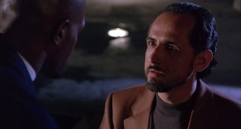 Movie still from “A Low Down Dirty Shame” (1994), directed by Keenen Ivory Wayans – A man with a beard talking to another man in front of him; Close Up shot, Over the shoulder angle