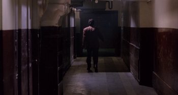 Movie still from “A Low Down Dirty Shame” (1994), directed by Keenen Ivory Wayans – A man walking down a hallway in the dark; Wide shot, High angle