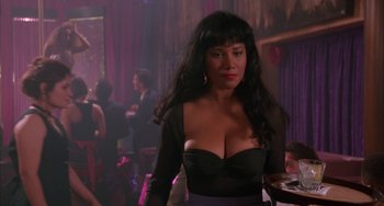 Movie still from “A Low Down Dirty Shame” (1994), directed by Keenen Ivory Wayans – A woman with long black hair wearing a black top; Medium shot, Over the shoulder angle