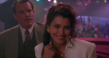 Movie still from “A Low Down Dirty Shame” (1994), directed by Keenen Ivory Wayans – A woman smiles brightly at the camera in front of a man; Close Up shot, Over the shoulder angle